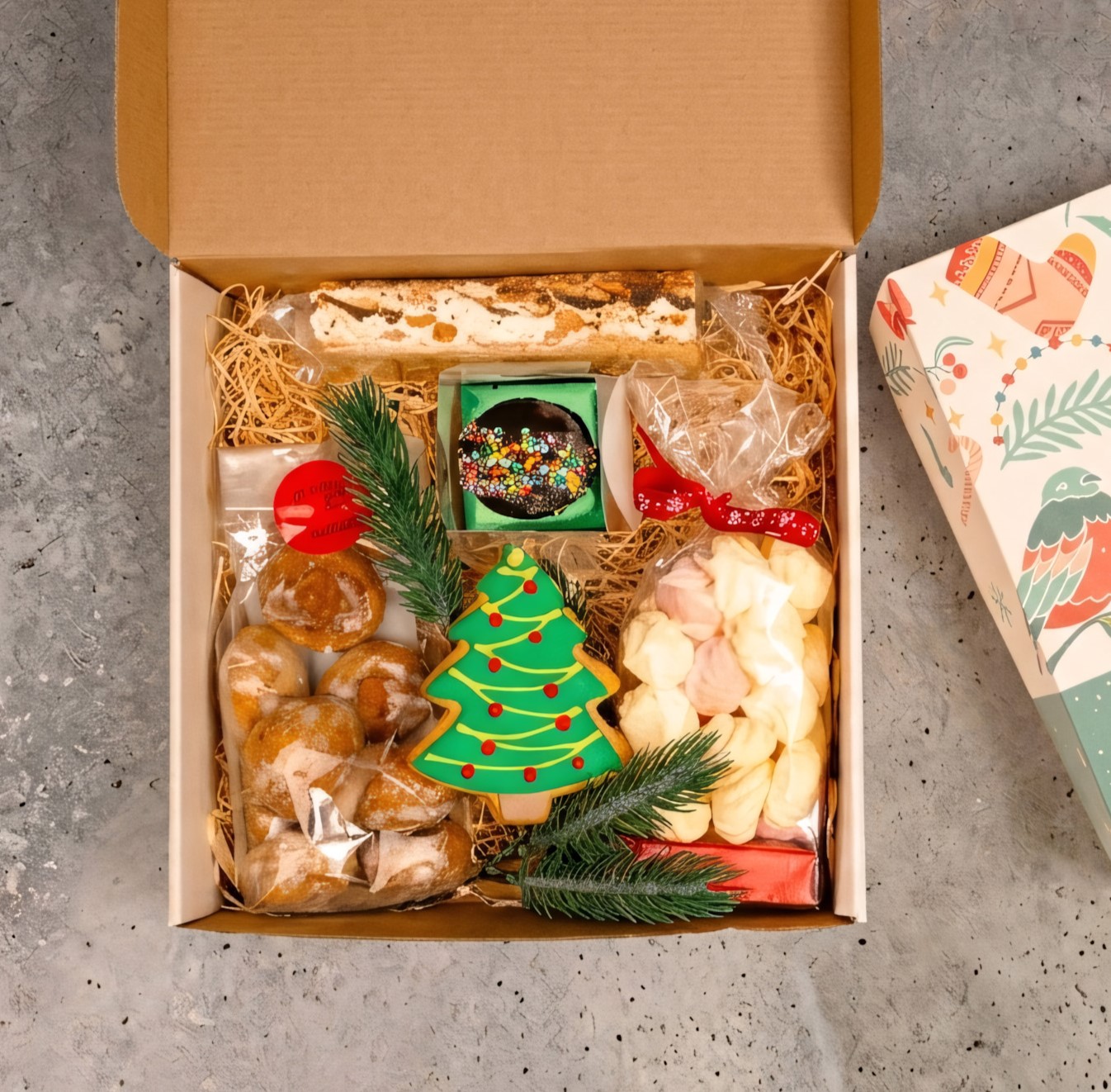 cos-cadou-craciun-bomba-ciocolata cutie pentru cadou din carton cu grafica de Crăciun, bisccuit în formă de brad, turtă dulce, bezele colorate, bombă de ciocolată caldă, halviță cu ciocolată
