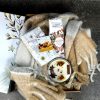 Cadou corporate de Crăciun cu pătură, cană festivă și produse pentru ciocolată caldă.